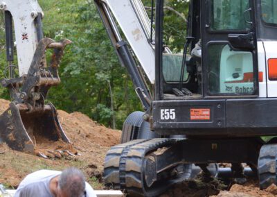 J & J Septic & Sewer team with Bobcat machine is working on the path clearing